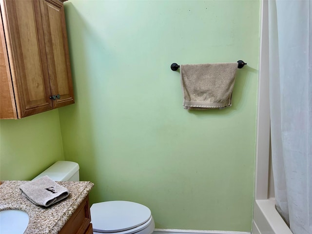 bathroom with vanity, toilet, a shower with curtain, and baseboards