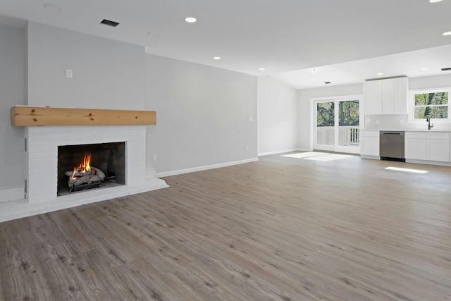21 Kent Rd, Hopewell Junction, NY 12533 - unfurnished living room featuring light wood-style flooring, visible vents, baseboards, recessed lighting, and a brick fireplace