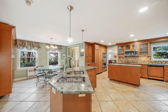 kitchen with recessed lighting, decorative backsplash, stainless steel appliances, a sink, and a center island