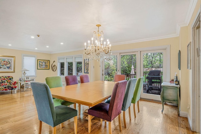 dining space featuring ornamental molding, an inviting chandelier, light wood-style floors, and french doors