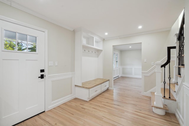 mudroom with ornamental molding, a decorative wall, and light wood-type flooring