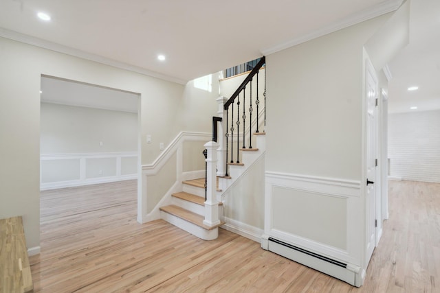 stairway featuring ornamental molding, a baseboard heating unit, recessed lighting, and wood finished floors