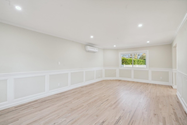 spare room with crown molding, a wall mounted AC, light wood-style floors, a decorative wall, and recessed lighting