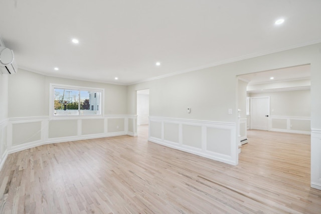 spare room featuring light wood-type flooring, recessed lighting, crown molding, and an AC wall unit