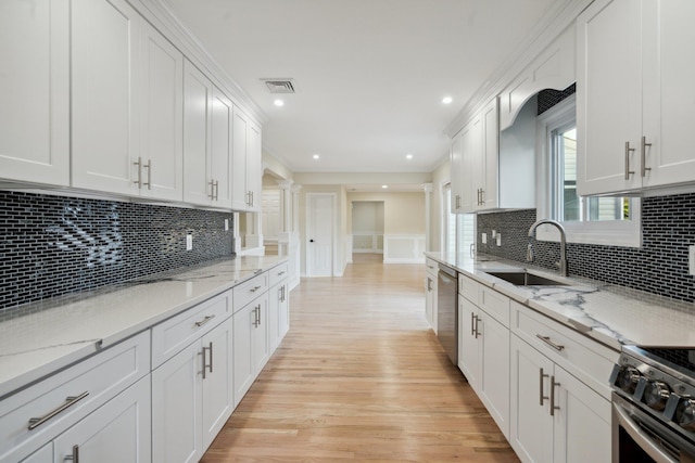 kitchen with appliances with stainless steel finishes, a sink, white cabinetry, light wood-type flooring, and visible vents