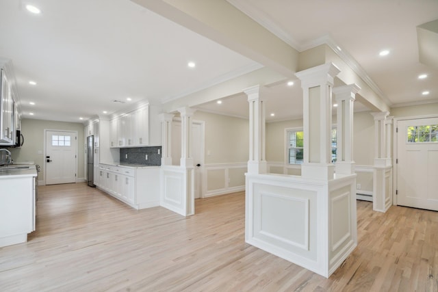 kitchen with light countertops, light wood-style flooring, and ornamental molding