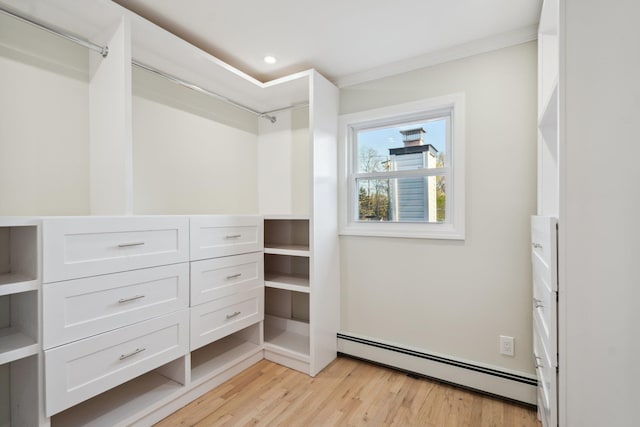 walk in closet with light wood-style floors and a baseboard radiator