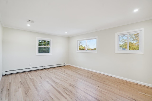 spare room with a wealth of natural light, wood finished floors, and a baseboard radiator