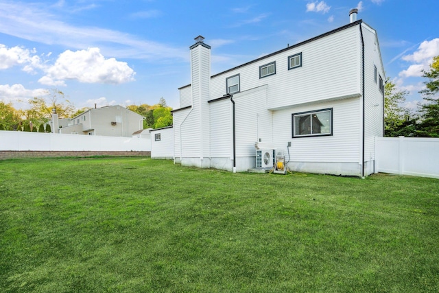 back of property featuring a yard, ac unit, fence, and a chimney