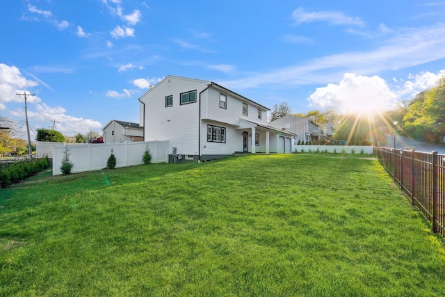back of house featuring a yard and a fenced backyard