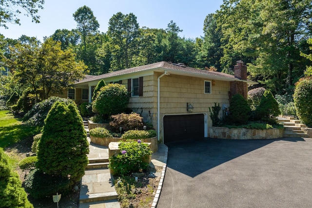 28 Stepping Stone Cres, Dix Hills, NY 11746 - view of side of property with a garage, asphalt driveway, and a chimney