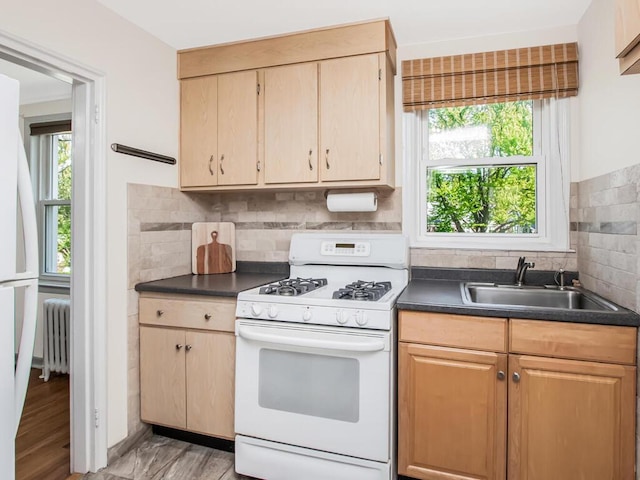 77 Hilltop Acres Unit 77, Yonkers, NY 10704 - kitchen with a sink, decorative backsplash, radiator heating unit, white appliances, and dark countertops