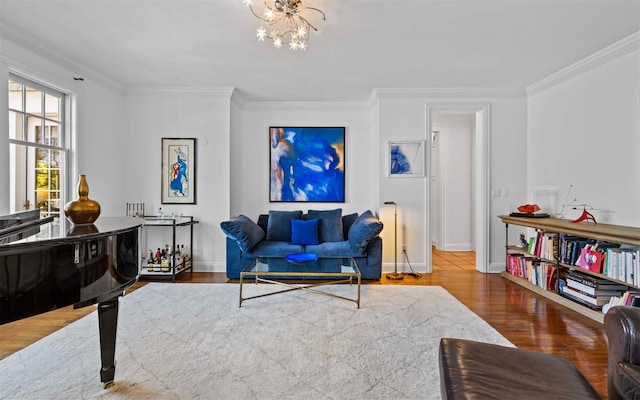 living room featuring baseboards, wood finished floors, an inviting chandelier, and crown molding