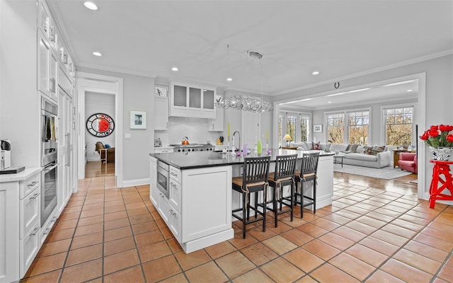 kitchen with ornamental molding, recessed lighting, a breakfast bar area, and glass insert cabinets