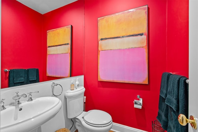 half bath featuring toilet and a sink