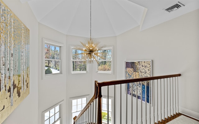 interior space with baseboards, visible vents, a notable chandelier, and high vaulted ceiling
