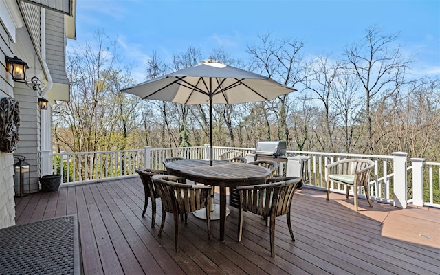 wooden terrace with a grill and outdoor dining area