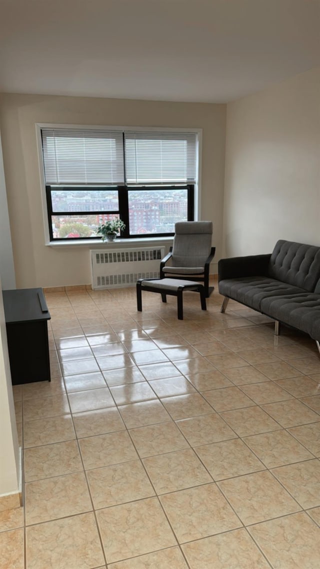 living room featuring radiator heating unit, a healthy amount of sunlight, and light tile patterned flooring
