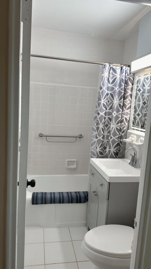bathroom with toilet, shower / bath combo with shower curtain, vanity, and tile patterned flooring