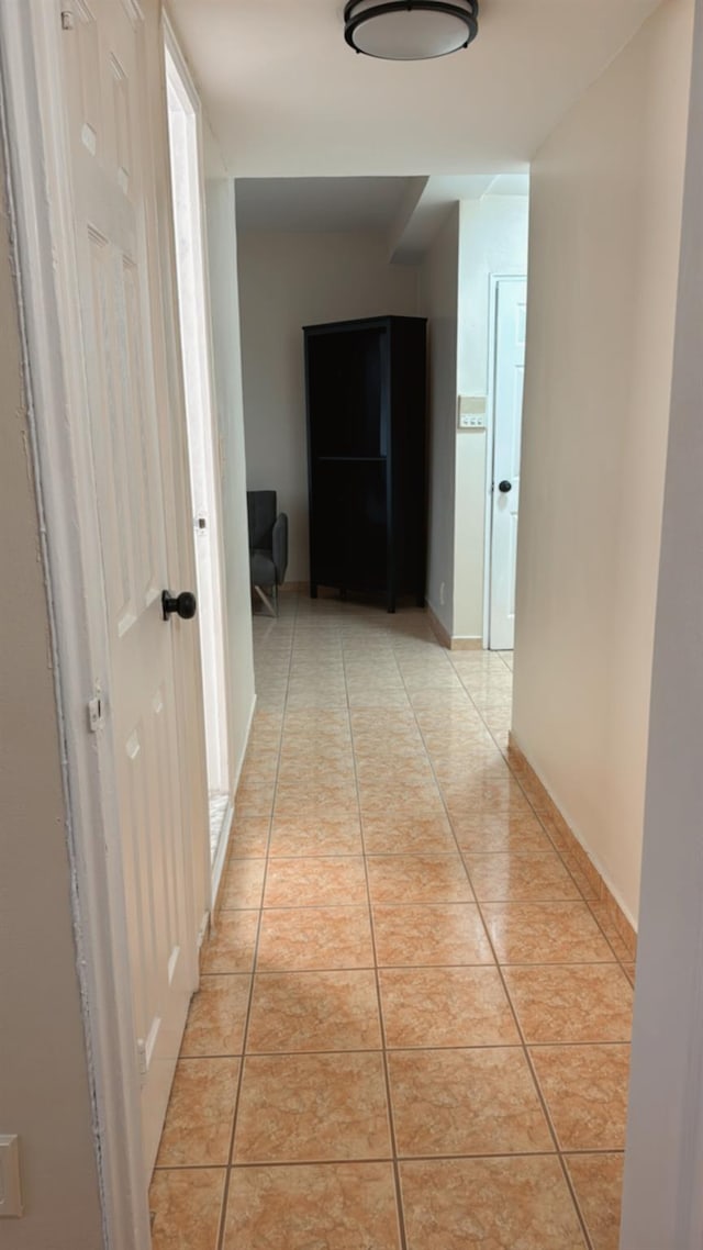 hall featuring light tile patterned floors