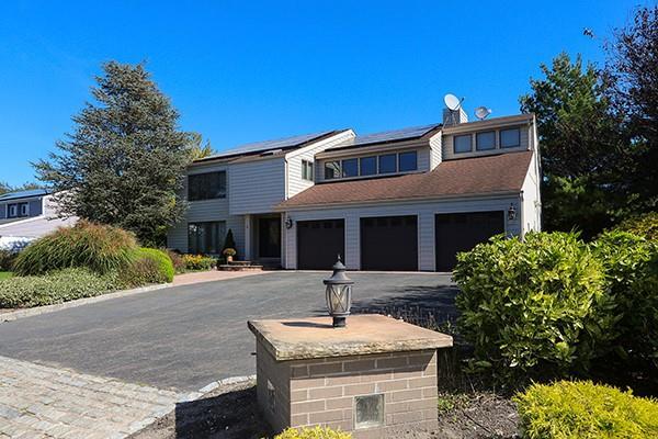 view of front of home with driveway, solar panels, and a garage