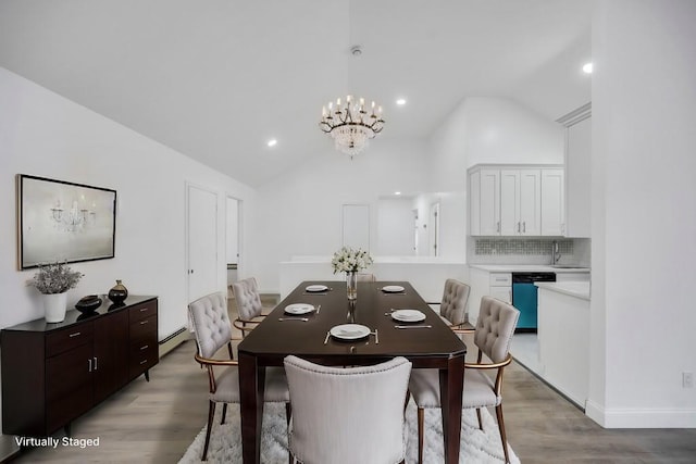 dining room with recessed lighting, vaulted ceiling, baseboard heating, light wood-type flooring, and a notable chandelier