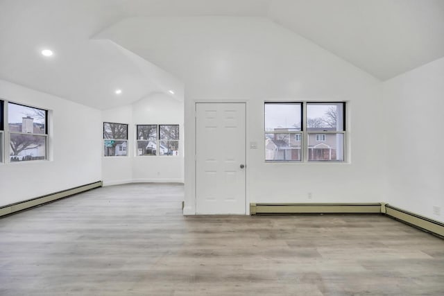 empty room with lofted ceiling, a baseboard radiator, plenty of natural light, and recessed lighting