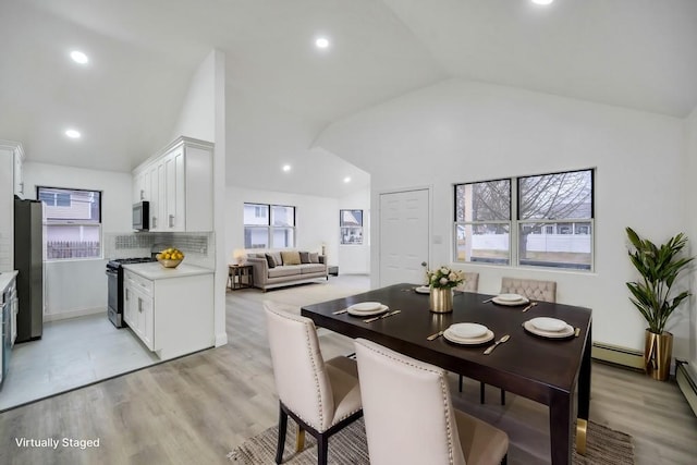 dining area with recessed lighting, high vaulted ceiling, baseboard heating, and light wood-style floors