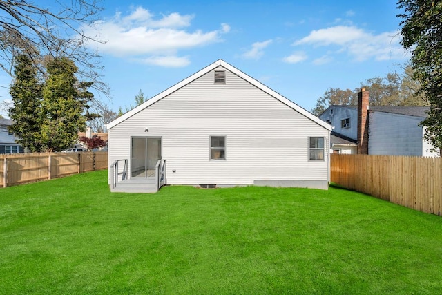 rear view of property with a yard and a fenced backyard