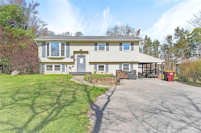 raised ranch featuring driveway and a front lawn
