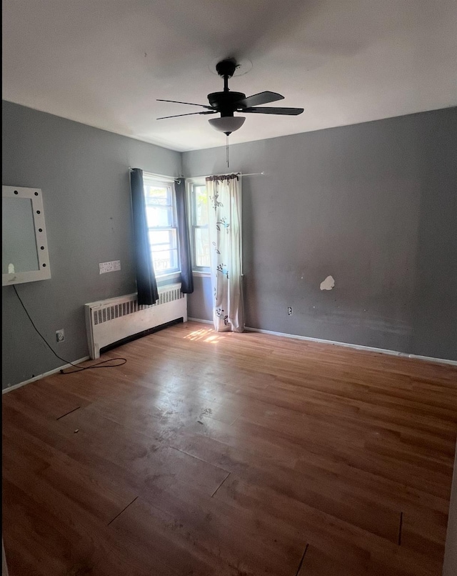 119 Broadfield Rd, Hempstead, NY 11550 - unfurnished room featuring a ceiling fan, radiator heating unit, wood finished floors, and baseboards