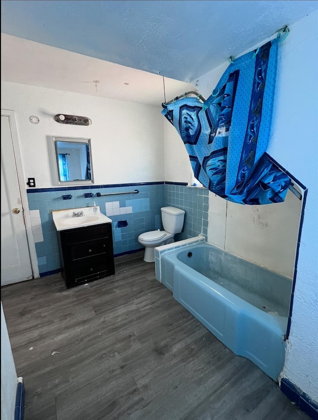 119 Broadfield Rd, Hempstead, NY 11550 - full bathroom featuring a wainscoted wall, toilet, tile walls, wood finished floors, and vanity