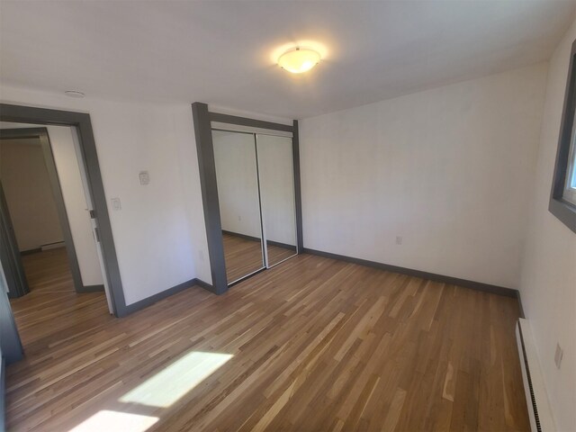 1404 Parr Lake Dr Unit 14D, Newburgh, NY 12550 - unfurnished bedroom with a closet, baseboard heating, light wood-style flooring, and baseboards