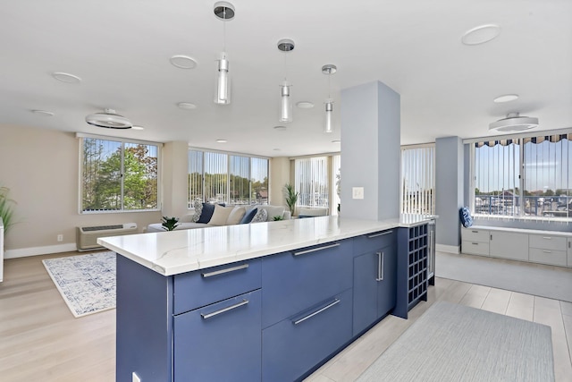 18 Shady Glen Ct Unit 302, New Rochelle, NY 10805 - kitchen featuring open floor plan, hanging light fixtures, light wood finished floors, and blue cabinets
