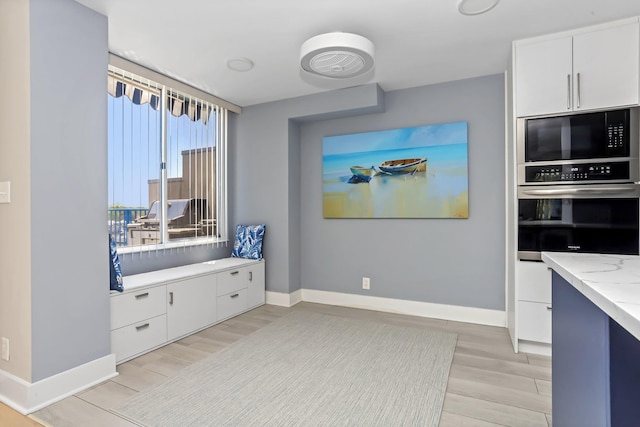 18 Shady Glen Ct Unit 302, New Rochelle, NY 10805 - kitchen with white cabinets, black microwave, stainless steel oven, light wood-style flooring, and baseboards