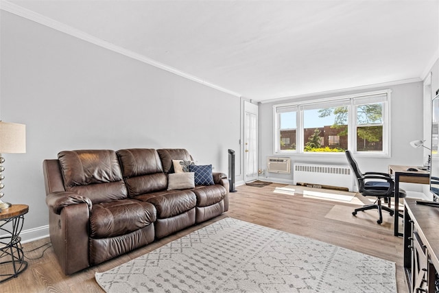 living room with baseboards, ornamental molding, light wood-style flooring, and radiator