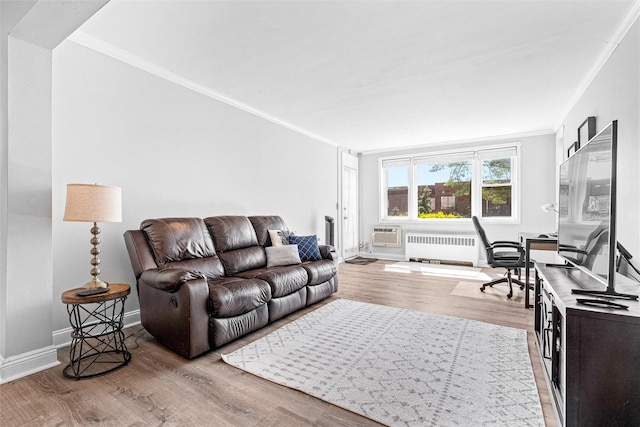 living room with radiator heating unit, baseboards, crown molding, and light wood-style flooring
