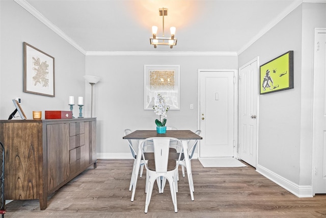 dining area with crown molding, baseboards, and wood finished floors