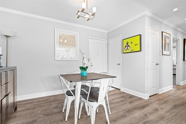 dining area featuring wood finished floors, baseboards, a chandelier, ornamental molding, and recessed lighting