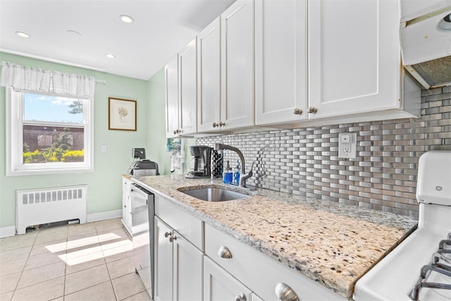 kitchen with range, tasteful backsplash, a sink, baseboards, and radiator heating unit