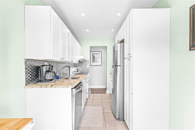 kitchen with white cabinets, a sink, stainless steel appliances, recessed lighting, and tasteful backsplash