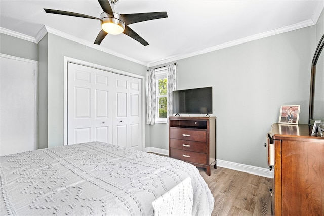 bedroom featuring ceiling fan, baseboards, wood finished floors, ornamental molding, and a closet