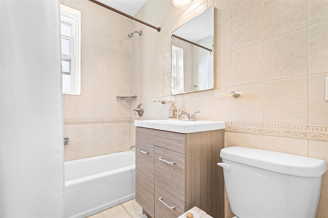 full bath featuring toilet, tile walls, shower / bathing tub combination, and vanity
