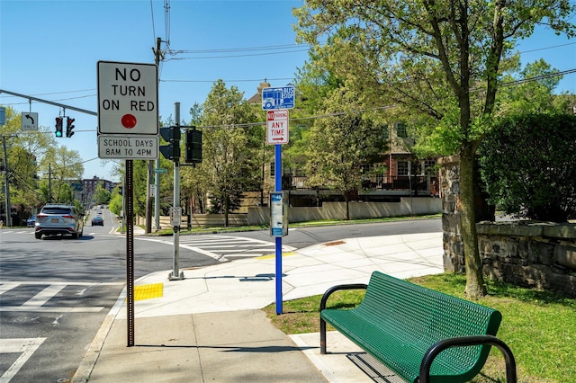 view of street featuring traffic lights, traffic signs, curbs, and sidewalks