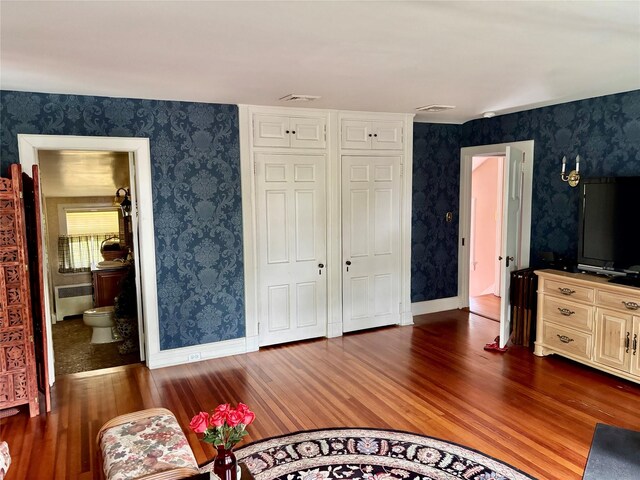12 W Mall Dr, West Hills, NY 11743 - bedroom with wood finished floors, radiator, wallpapered walls, and a closet