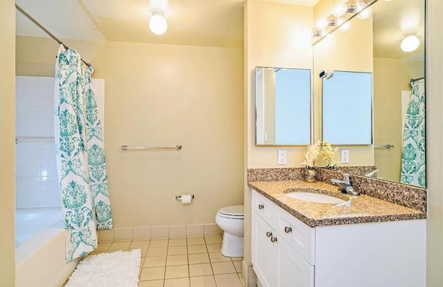bathroom with vanity, toilet, baseboards, tile patterned floors, and shower / bath combo