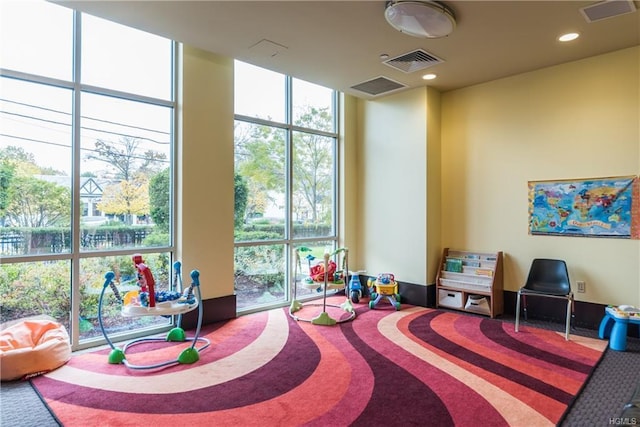 game room featuring visible vents, floor to ceiling windows, and carpet floors