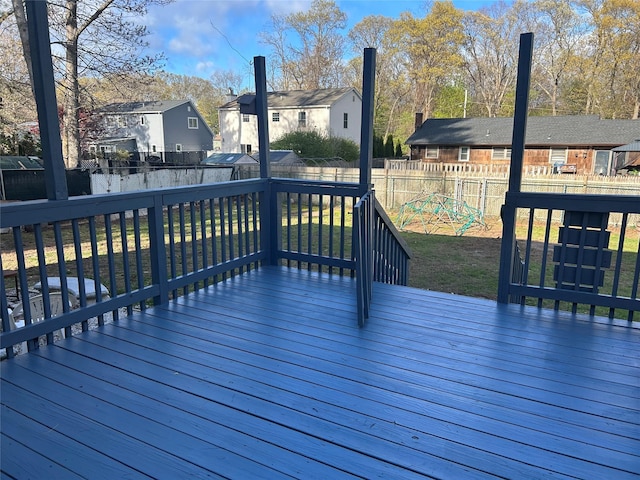 wooden deck with a residential view, a lawn, and a fenced backyard