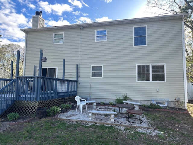 back of property featuring a wooden deck and a chimney