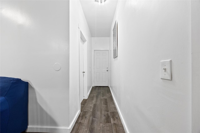 hall with dark wood-style floors and baseboards